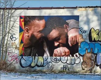  ?? CONTRIBUTE­D PHOTOS ?? Brothers Tony and Cal Smith now have a photo of themselves embraced in a hug on a building located at Germantown Street and Dennison Avenue in Dayton.