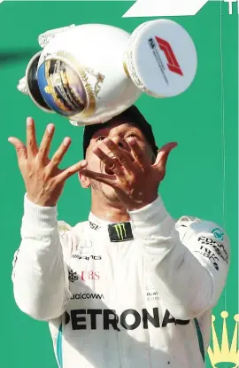  ?? Picture: AFP ?? SAFE HANDS. Lewis Hamilton does his signature trophy toss on the podium after winning the Hungarian Formula One Grand Prix at the Hungarorin­g yesterday.