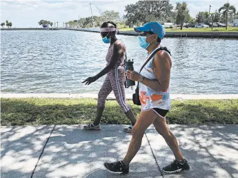  ?? TAMARA LUSH/AP ?? Eva Johnson, left, and Liz Cillo walk by the waterfront Wednesday in St. Petersburg, Fla. Cillo, 72, feels the president hasn’t shown empathy toward seniors.