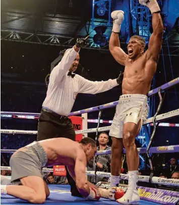  ?? Foto: Axel Heimken, dpa ?? Der Anfang vom Ende in Runde elf: Wladimir Klitschko, schwer getroffen, auf allen Vieren. Anthony Joshua reißt triumphier­end die Fäuste in die Höhe.