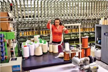  ?? ARIS MESSINIS/AFP ?? A woman works at a silk fabric factory in the Greek northern town of Soufli.