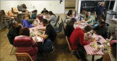  ?? MARCIO JOSE SANCHEZ — THE ASSOCIATED PRESS ?? A group of homeless people, including Ellen Tara James-Penney (wearing blue) left, a lecturer at San Jose State University, receive a meal at Grace Baptist Church in San Jose. The booming economy along the West Coast has led to an historic shortage of...