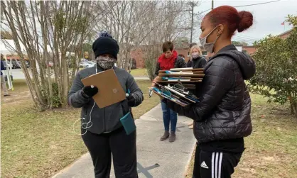  ?? Photograph: Sue Dorfman/ZUMA Wire/REX/Shuttersto­ck ?? A worker collects clipboards and pens from voters in Savannah as early voting continues in Georgia on 15 December.