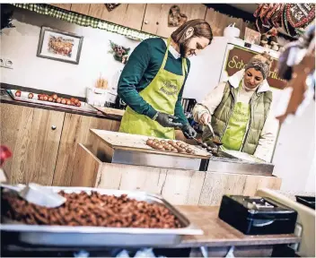  ?? FOTO: ANDREAS ENDERMANN ?? Leckerei per Hand gemacht: Schaustell­erin Jasmin Wilmering zeigt unserem Autor, wie man Erdbeeren mit einer Schicht aus feiner dunkler Schokolade überzieht – eine fast gesunde Weihnachts-Nascherei.