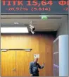  ??  ?? MARKET: A man takes pictures of prices in Athens stock exchange.
