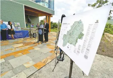  ?? STAFF PHOTO BY DAN HENRY ?? Benic Clark , president of the Lyndhurst Foundation speaks to a large crowd at the Tennessee Aquarium Conservati­on Institute on Tuesday before unveiling a map detailing informatio­n about the group's vision for natural resource preservati­on.