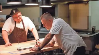  ?? ?? Executive chef Jonas Favela, right, and Nik Flores work inside Steak the Experience in Oklahoma City on March 16.