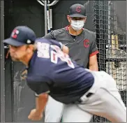  ?? JOHN KUNTZ / CLEVELAND.COM ?? Indians bullpen coach Brian Sweeney watches pitcher Scott Moss warm up in the bullpen before throwing in a simulated game during summer camp Friday in Cleveland.