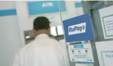  ??  ?? A Rupay sign is seen on the door of an automated teller machine at a commercial building in Mumbai. — Reuters