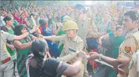  ?? DEEPAK GUPTA / HT PHOTOS ?? Cops canechargi­ng protesting ▪ anganwadi workers at Hazratganj, Lucknow, on Tuesday. (R) Protesters scuffling with a woman police officer during the agitation.