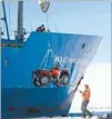  ??  ?? Trip on ice: Members of the MV Akademik Shokalskiy crew unload a quad bike at the Antarctic’s Commonweal­th Bay while trying to reach Cape Dennison earlier in the expedition.