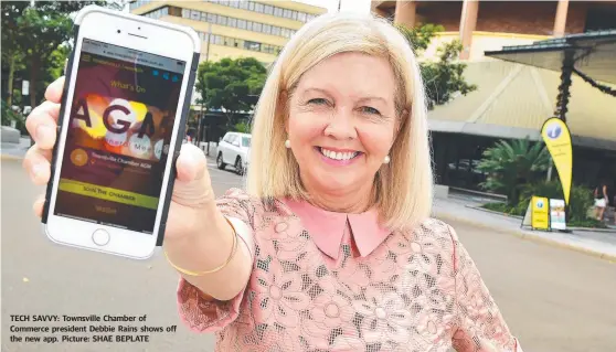  ??  ?? TECH SAVVY: Townsville Chamber of Commerce president Debbie Rains shows off the new app. Picture: SHAE BEPLATE