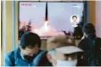  ?? Foto: dpa ?? Südkoreane­r gehen an einem TV-Bildschirm vorbei, auf dem ein Bericht über Nordkoreas Raketentes­t läuft.