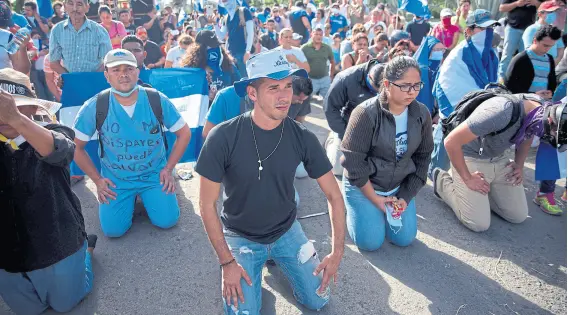  ?? Carlos herrera/dpa ?? Manifestan­tes en apoyo de los estudiante­s sitiados en una parroquia, ayer, frente a la policía, en Managua