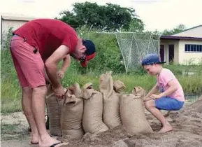  ?? REUTERS PIC ?? Residents filling sandbags in preparatio­n for the arrival of Cyclone Debbie in the northern Australian town of Bowen yesterday.