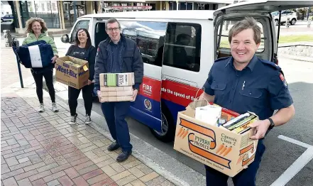  ?? JOHN BISSET/ STUFF ?? Timaru firefighte­rs are helping the Aoraki Migrant Centre deliver care packages to migrant families in need during lockdown. Mandy Wills, left, Katy Houston, Bevan Findlay and Craig Chambers sort parcel delivery this week.