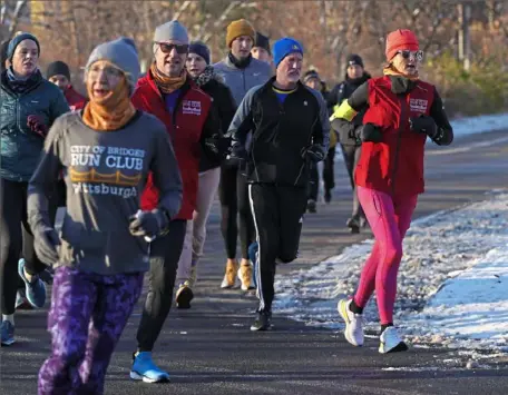  ?? Emily Matthews/Post-Gazette ?? Kim Lambert, with City of Bridges Run Club, right, runs with others during the Pittsburgh Marathon Kickoff Training Run on the North Shore.