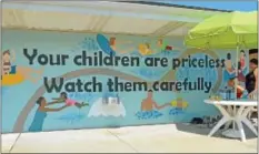  ?? News-herald photo — DEBBY HIGH ?? The new mural at the Menlo Park Pool reads “Your children are priceless, Watch them carefully.”