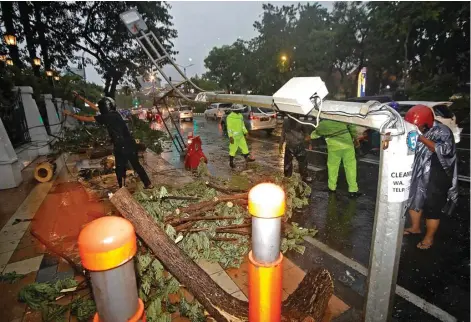  ?? DIPTA WAHYU/JAWA POS ?? PORAK-PORANDA: Tiang listrik di Jalan Raya Darmo, Surabaya, roboh diterjang angin kencang yang mengiringi hujan deras kemarin sore.