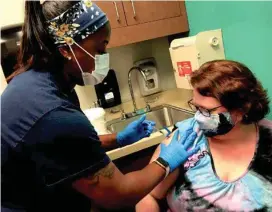  ?? TNS PHOTO:/BILL LAITNER ?? Ruth Bourseleth, 45, of White Lake gets a COVID booster shot earlier this month at the Gary Burnstein Community Health Clinic in Pontiac, one of about 60 free clinics in Michigan.