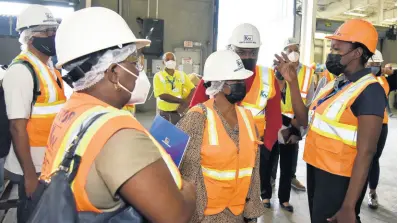  ?? ?? Yanique Orr-Whyte Sr (right), warehouse operations coordinato­r, explaining aspects of the operations at Kingston Wharves Limited to a visiting delegation from Barbados, which is conducting a two-day tour of the island’s shipping ports.
