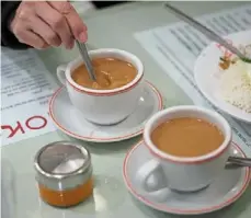  ?? —AP ?? Taste of home: a customer stirring her cup of Hong Kong-style milk tea at the Hoko Cafe in London.