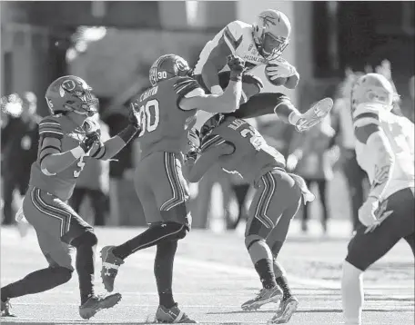  ?? Rick Bowmer Associated Press ?? ARIZONA STATE RUNNING BACK Kalen Ballage hurdles the Utah defense during the Sun Devils’ 30-10 victory at Salt Lake City.