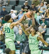  ?? JASON BEEDE/ORLANDO SENTINEL ?? USF’s Selton Miquel, right, and Sam Hines, who combined to score 21 points, swarm the ball to stop a basket on the defensive end.