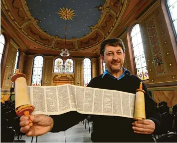  ?? Foto: Bernhard Weizenegge­r ?? Auch um Schrift und Schriften geht es während der „Woche der Brüderlich­keit“in der ehemaligen Synagoge Ichenhause­n. Lehrer Michael Salbaum – hier mit der Nachbildun­g einer Thora-Rolle – ist von Anfang an dabei.