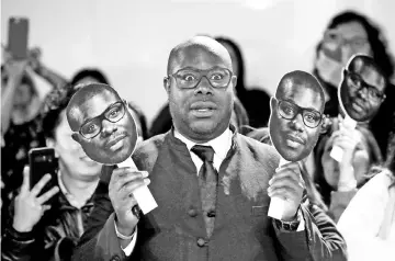  ??  ?? Director Steve McQueen holds masks of himself as he arrives for the world premiere of ‘Widows' at the Toronto Internatio­nal Film Festival (TIFF) in Toronto, Canada, Sunday. — Reuters photos