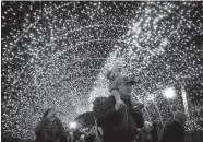  ?? JOHN MINCHILLO/AP PHOTO ?? Visitors pass through a tunnel of holiday lights during the Cincinnati Zoo & Botanical Garden Festival of Lights earlier this month in Cincinnati.