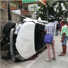  ??  ?? Curious onlookers check the private car that lies on its side after it hit a multicab along H. Cortes Street in Mandaue City.