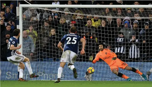  ?? — AFP ?? West Bromwich Albion’s Jay Rodriguez ( left) scores against Arsenal in their English Premier League match at the Hawthorns Stadium in West Bromwich on Sunday. The match ended 1- 1.