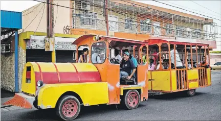  ?? FEDERICO PARRA / AFP ?? Necesidade­s. Personas usan como transporte público un tren de diversión para niños, en Maracaibo, capital del estado petrolero de Zulia.