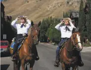  ?? Celia Talbot Tobin / New York Times ?? JACKSON, WYO.: Catherine Tallichet and husband Tim Oakley saddle up with the Citizens Mounted Unit for a look as the eclipse passed overhead.