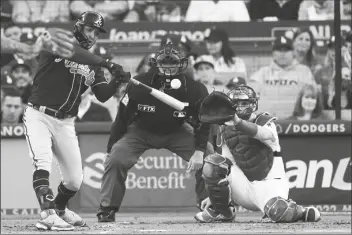  ?? MARCIO JOSE SANCHEZ/AP ?? ATLANTA BRAVES’ EDDIE ROSARIO hits a solo home run during the second inning in Game 4 of the National League Championsh­ip Series against the Los Angeles Dodgers Wednesday in Los Angeles.