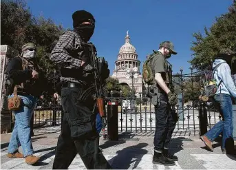  ?? Lisa Krantz / Staff photograph­er ?? Armed demonstrat­ors walk past the State Capitol in Austin on Sunday.