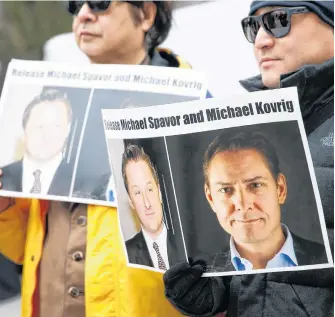 ?? REUTERS FILE • LINDSEY WASSON ?? People hold signs calling for China to release Canadian detainees Michael Spavor and Michael Kovrig during an extraditio­n hearing for Huawei Technologi­es Chief Financial Officer Meng Wanzhou at the B.C. Supreme Court in Vancouver on March 6, 2019.