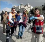  ?? AP ?? Medics evacuate a Palestinia­n man wounded by Israeli security forces during the protests outside Jerusalem’s Old City.