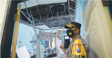  ?? (Irfan Anshori/Antara Foto via Reuters) ?? A POLICE OFFICER stands by a damaged room at a hospital caused by a 5.9-magnitude earthquake striking the ocean 91 km. south-southeast of Blitar in Indonesia’s East Java province yesterday.