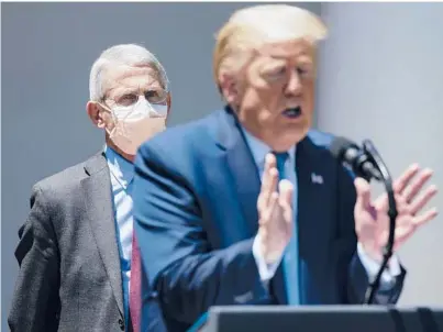  ??  ?? Dr. Anthony Fauci listens as President Donald Trump speaks to reporters May 15 at the White House.