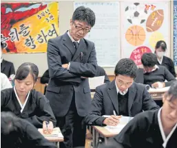  ??  ?? STUDIOUS: A teacher observes his students as they take an exam at the Korean High School in Tokyo.