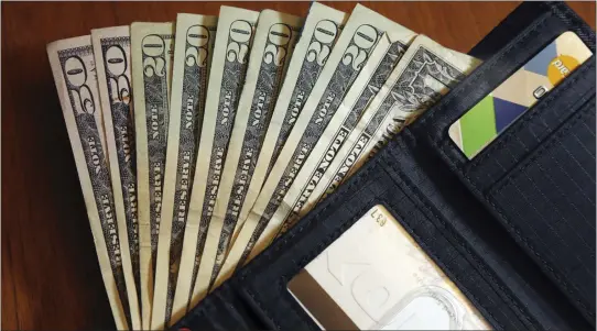  ?? ASSOCIATED PRESS FILE PHOTO ?? Cash is fanned out from a wallet in North Andover, Mass.