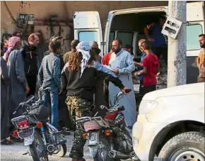  ??  ?? Desperate times: Displaced Syrians queuing up to receive bread from a Turkish NGO in the town of Ayn al-Arus. — AFP