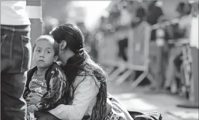  ?? [GREGORY BULL/THE ASSOCIATED PRESS] ?? A woman sits with her son Tuesday while waiting to apply for asylum to the United States in Tijuana, Mexico.