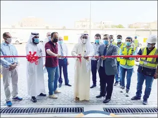  ??  ?? Director of Ahmadi Health Zone Dr Ahmad Al-Shatti cuts the ribbon to inaugurate the car park.