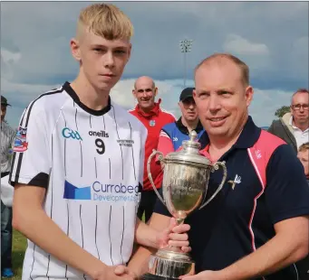  ??  ?? Mattock Hunterstow­n’s James Rogers receives U14A Championsh­ip trophy from Stephen Murphy.