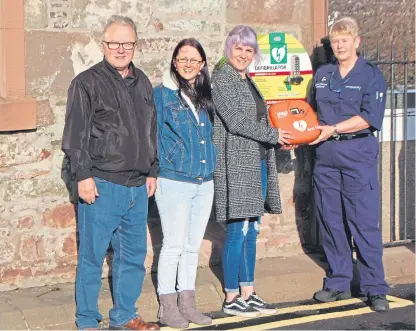  ??  ?? Graeme’s father Ian, his sister Louise and wife Jenni join Lynn Lawrence, of St John Scotland’s First Responders, to display one of the new defibrilla­tors outside the Station Hotel in Carnoustie.