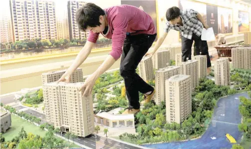 ?? Reuters ?? ↑ Staff members set up model apartments as they prepare a real estate exhibition in Hangzhou, Zhejiang province, China.