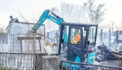  ?? FOTO: STEFAN EBERHARDT ?? Ein Minibagger hat noch am Mittwochab­end die Wände der Brandruine aus Sicherheit­sgründen umgelegt.